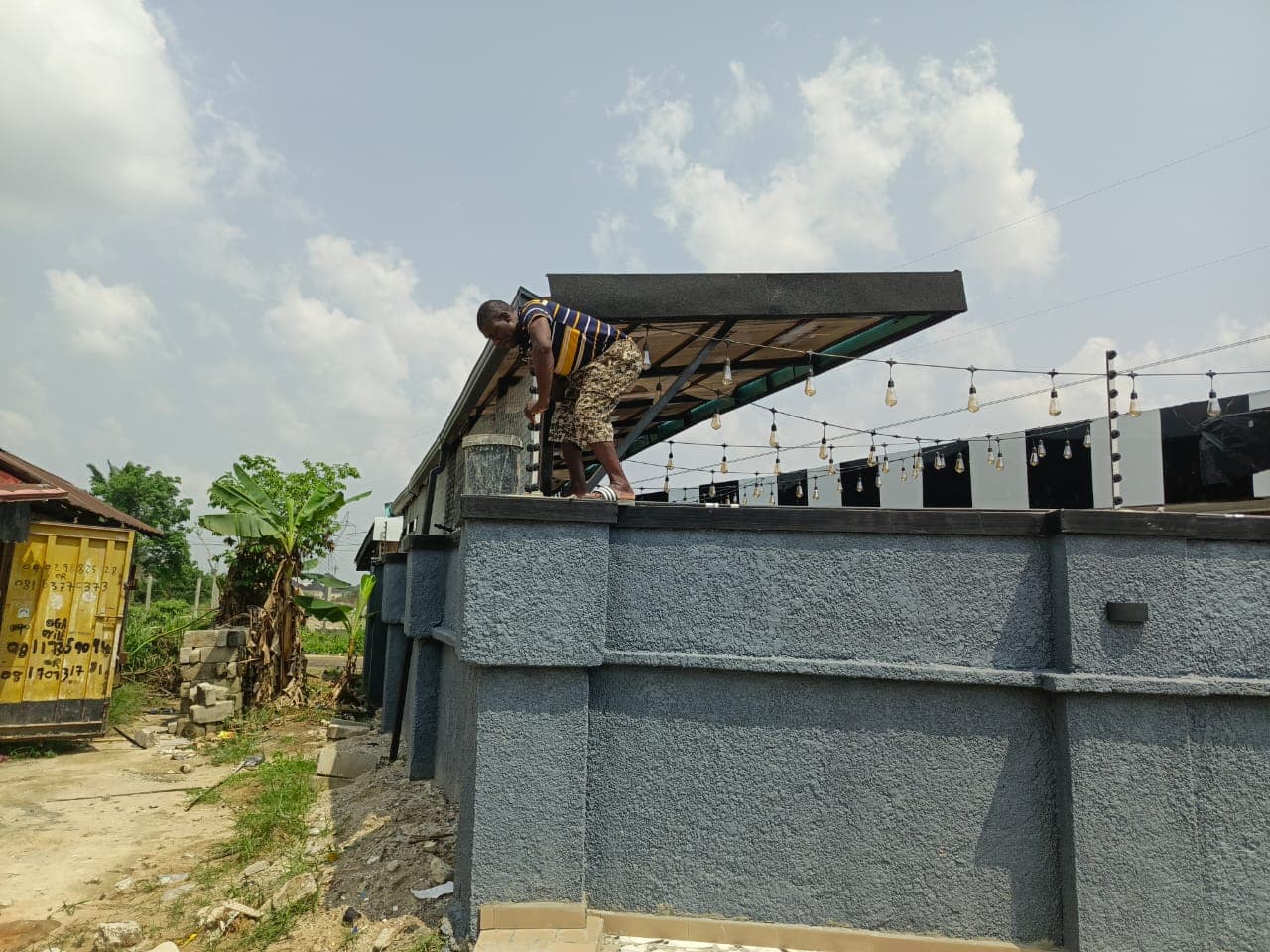 An electric fence installation technician installing an electric fence for a house